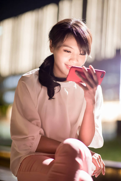 mulher usar telefone e assistir vídeo feliz com shopping center à noite
 - Foto, Imagem