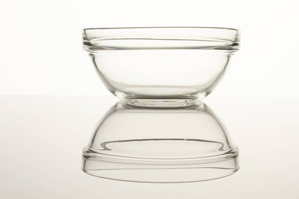 Glass bowl on reflective surface. - Foto, Imagen