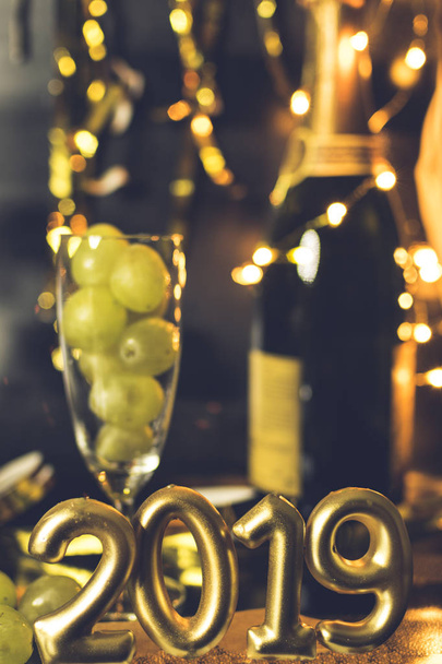 End of the year concept. Glass of champagne with grapes inside, with holiday decoration - Foto, Imagem