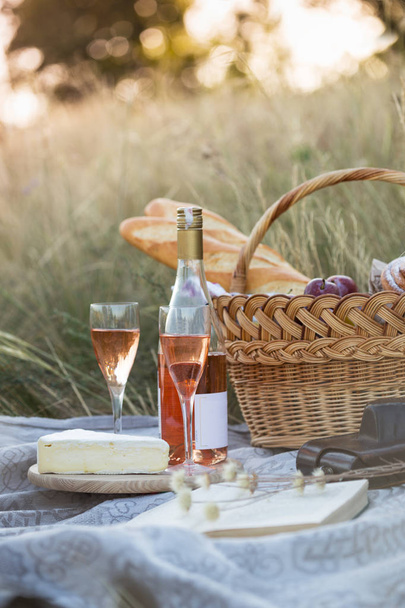 Summer - Provencal picnic in the meadow.  baguette, wine, glasses, grapes, Cheese brie, baguette in a basket - Foto, Bild