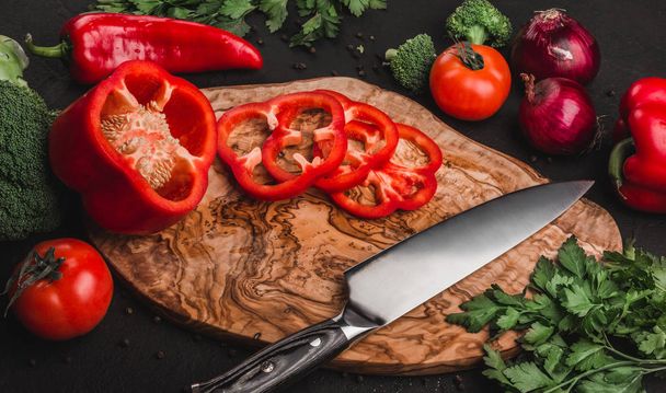 まな板石の背景、調理食品の上にナイフで野菜。テーブルの上の食材。健康食品のコンセプトです。トップ ビュー - 写真・画像