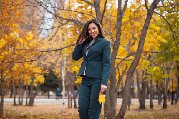 Woman calling by phone. Happy successful arab businesswoman in blue suit walking in autumn park - Fotografie, Obrázek