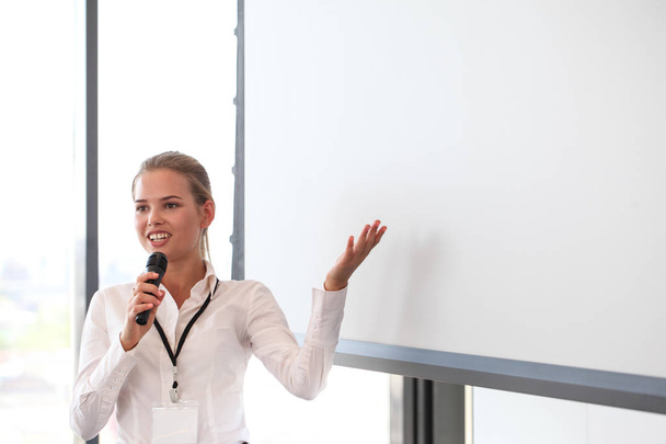 Business woman giving a presentation on blank white board with copy space - Foto, Bild