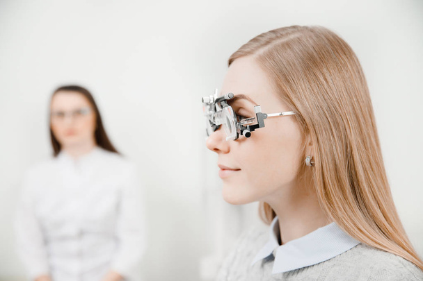 Офтальмолог женщина врач проверяет диагноз близорукость зрения, гиперопия молодая женщина
. - Фото, изображение