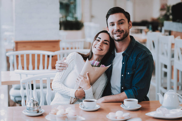 Happy People. Flowers Bunch. Boyfriend. Romantic Relationship. Sweet Relationship. Together in Cafe. Drink Tea. Eat Cakes. In Love. Cuple. Boy Gift Flowers. 8 March Celebration. Gift. Valentines Day. - Foto, imagen
