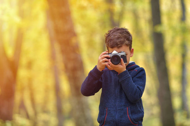 Twórcze dziecko, dziecko fotograf (mały chłopiec) z kamery Robienie zdjęć kolorowych jesienny Las - Zdjęcie, obraz