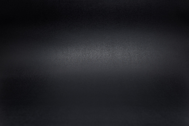 Fekete, durva textúrázott háttérre félhomályban megvilágított. - Fotó, kép