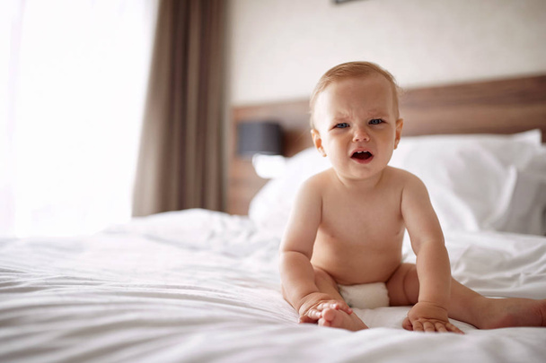 Adorable little boy is crying in the bed - Foto, afbeelding