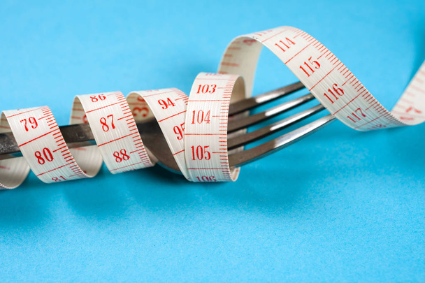 fork with centimeter on a blue background, diet, healthy lifestyle. - Foto, Bild