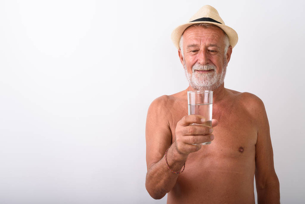 Homem sênior sem camisa segurando vidro de água
 - Foto, Imagem