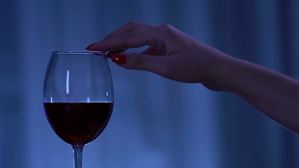 Womans hand with perfect manicure seductively touching glass with red wine - Materiał filmowy, wideo