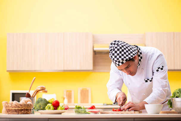 Nuori ammattilainen kokki valmistelee salaattia kotona - Valokuva, kuva
