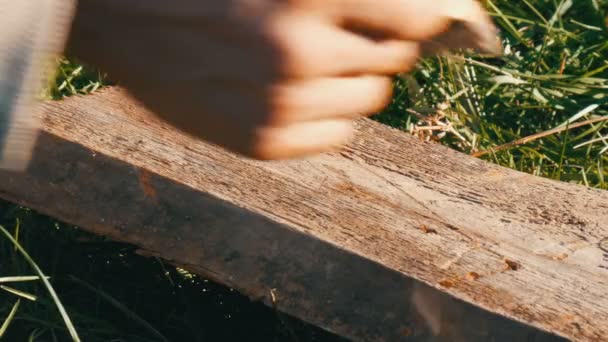Man hammering used long nail into old boards - Footage, Video
