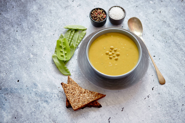 Green pea cream soup in grey bowl - Photo, Image