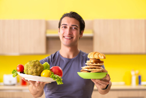 Człowiek mający trudny wybór między zdrową i niezdrową żywnością - Zdjęcie, obraz