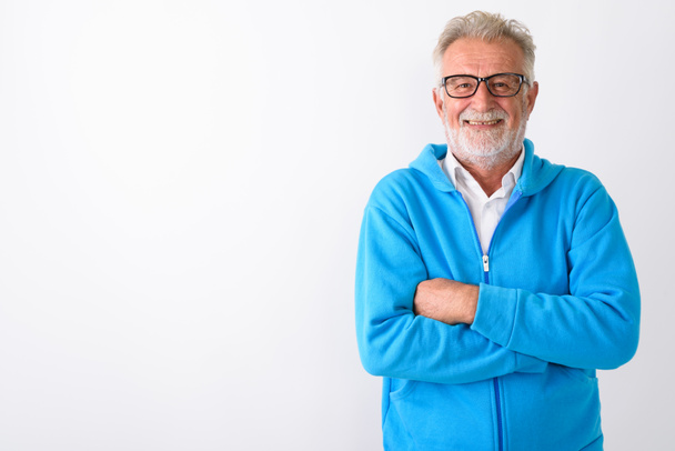 Studio shot of happy senior bearded man smiling with arms crosse - Foto, afbeelding