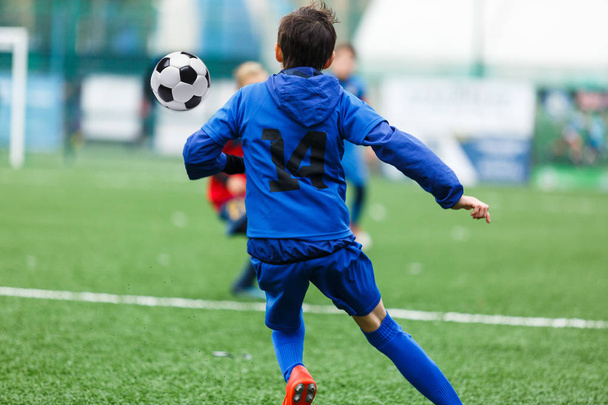 football teams - boys in red, blue sportswear  play soccer on the green field. boys dribbling. dribbling skills. Team game, training, active lifestyle, hobby, sport for kids concept - Foto, Bild