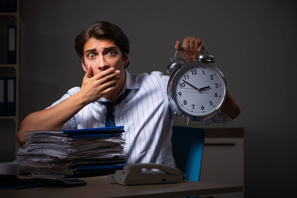 Jovem gerente financeiro trabalhando até tarde da noite no escritório
  - Foto, Imagem