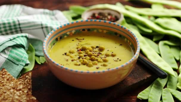 Sopa de crema de guisantes verdes en tazón gris - Imágenes, Vídeo