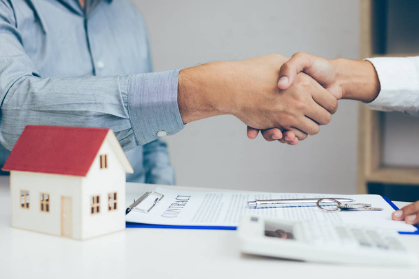 Gros plan de serrer la main d'un client et d'un courtier immobilier après avoir signé un contrat au bureau à domicile
. - Photo, image
