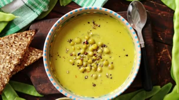 Sopa de crema de guisantes verdes en tazón gris - Metraje, vídeo