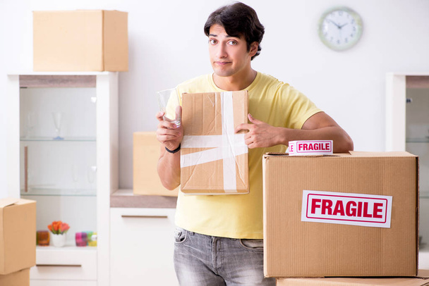 Hombre mudanza casa y reubicación con elementos frágiles
 - Foto, Imagen
