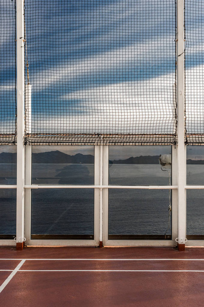 Containment netting and glass access doors on a cruise ship sports deck. - Photo, Image