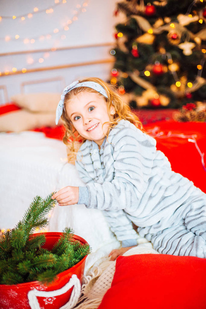 A karácsony reggel pizsamában kislány. Vidám Christmas.Little lány örül, hogy a karácsonyi ajándék - Fotó, kép