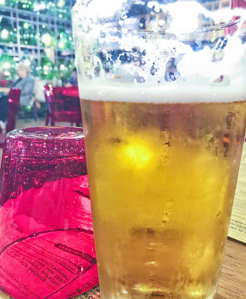 gelido bicchiere d'oro di birra in un ristorante pizzeria
  - Foto, immagini