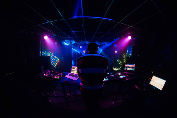 DJ voert in nachtclub en speelt muziek - Foto, afbeelding