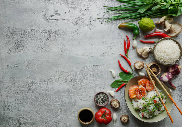 Teppanyaki sült rizs garnélarák, gomba, zöld hagyma, paprika és gyógynövények a könnyű beton háttér-val másol hely - Fotó, kép