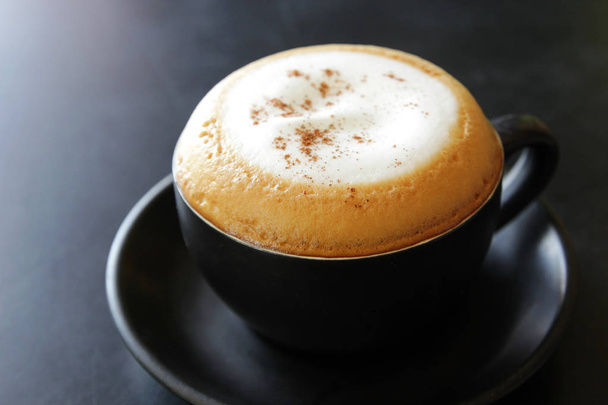 filiżankę gorącej cappuccino coffee na czarny stół - Zdjęcie, obraz