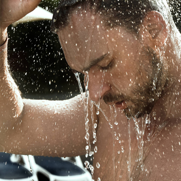 Mladý pohledný a atraktivní muž s svalnaté tělo mokré osprchování v lázni. hezký atraktivní muži sprchování u bazénu. kapky vody padají na jeho trupu - Fotografie, Obrázek