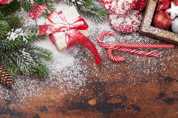 Karácsonyi kártya ajándék doboz, édességet vesszők, dekoráció és a karácsonyi fenyő fa ága a fából készült asztal - Fotó, kép