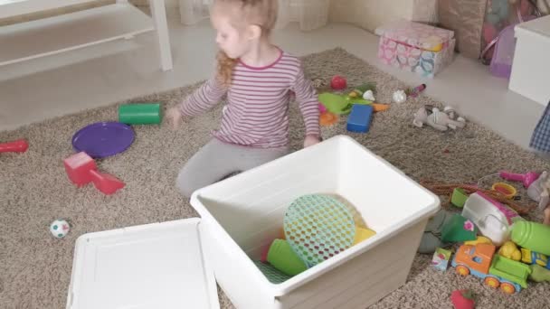 Linda criança rindo, loira pré-escolar, brincando com brinquedos coloridos, sentada no chão no quarto 4k
 - Filmagem, Vídeo