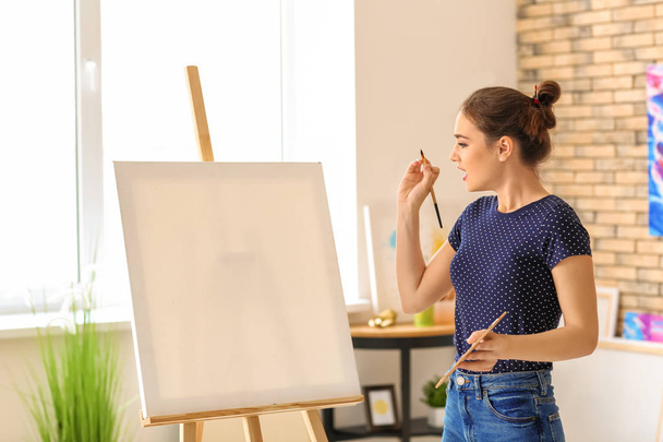 Female artist painting picture in workshop - Фото, зображення