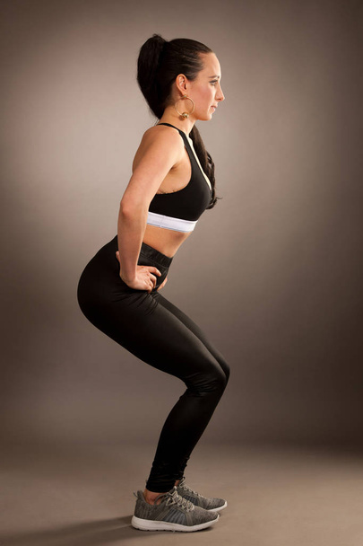 Woman work out squat over gray background . - Foto, immagini