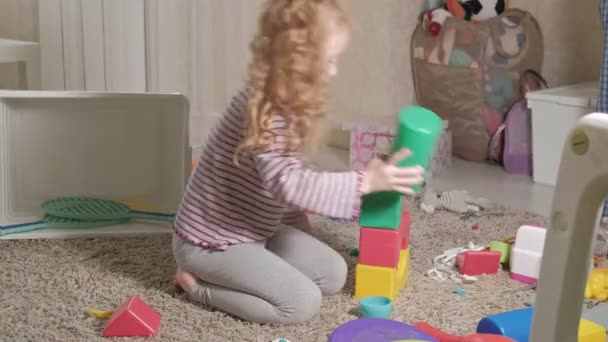 Precioso niño riendo, rubia preescolar, jugando con juguetes coloridos, sentado en el suelo en la habitación
 - Metraje, vídeo