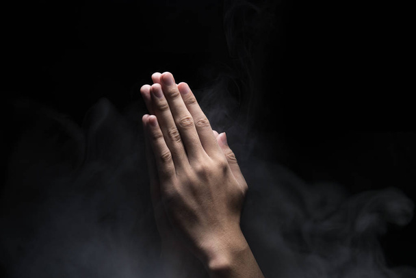 Hands with praying gesture over dark background. Christian Pra - Photo, Image