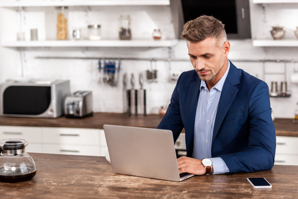 handsome businessman in formal wear using laptop at home   - Zdjęcie, obraz