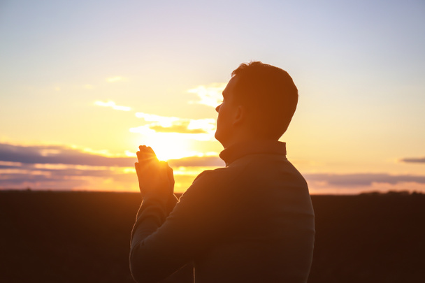 夕暮れ時の屋外祈り宗教的な男 - 写真・画像
