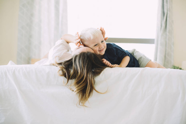 Glücklich liebende Familie. Mutter spielt mit ihrem Baby im Schlafzimmer - Foto, Bild