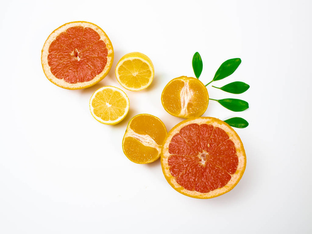 Halves of fresh ripe citrus fruits on white background - Фото, изображение