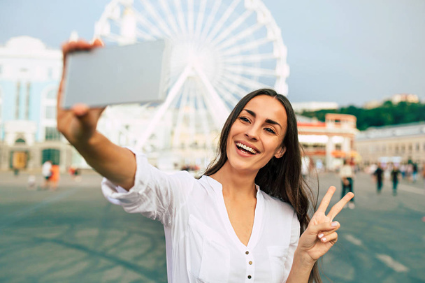 Young happy woman using smartphone on city square - Zdjęcie, obraz