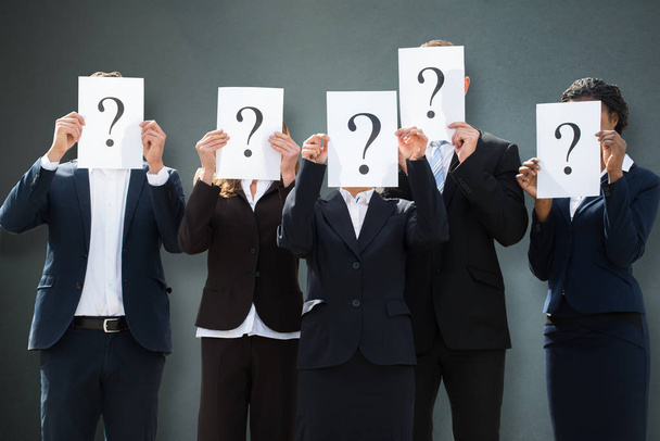 Group Of Businesspeople Hiding Their Faces Behind Question Mark Sign On Grey Background - Foto, immagini
