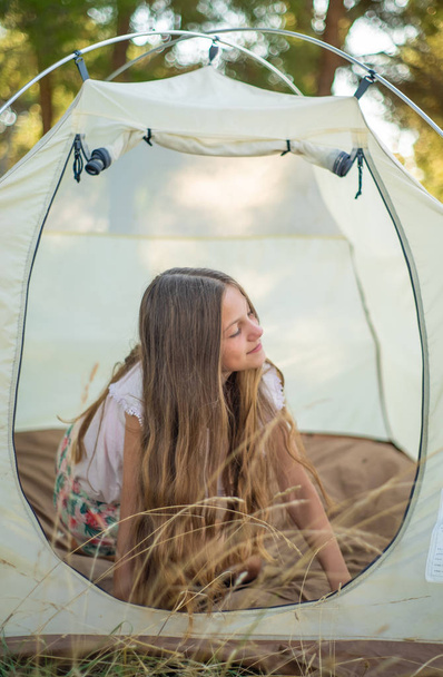Young pretty teenage girl in tent. - Foto, afbeelding