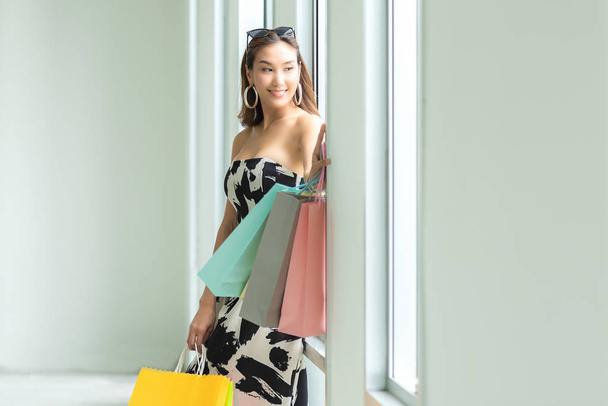 Asian smiling woman so happy shopping online with her shopping in casual clothing with shopping bags.  Lifestyle Concept - Фото, изображение