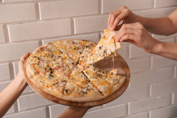 female hands taking piece of pizza, Close up view  - Foto, Imagen