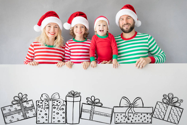 Family holding cardboard banner blank. Happy people playing at home. Christmas holiday concept. Copy space. - Фото, изображение