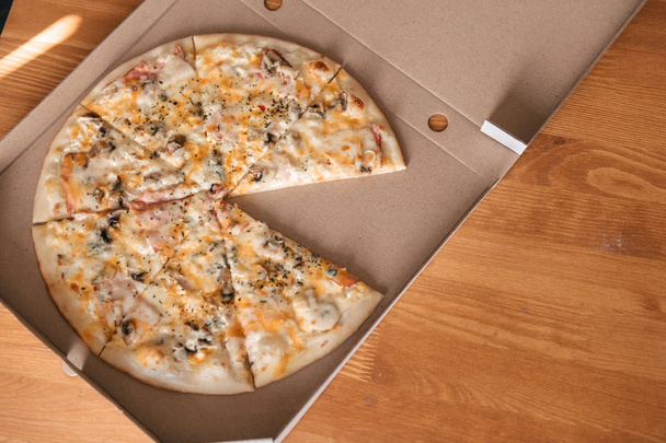 Vista de cerca de la deliciosa pizza en caja de cartón
 - Foto, imagen